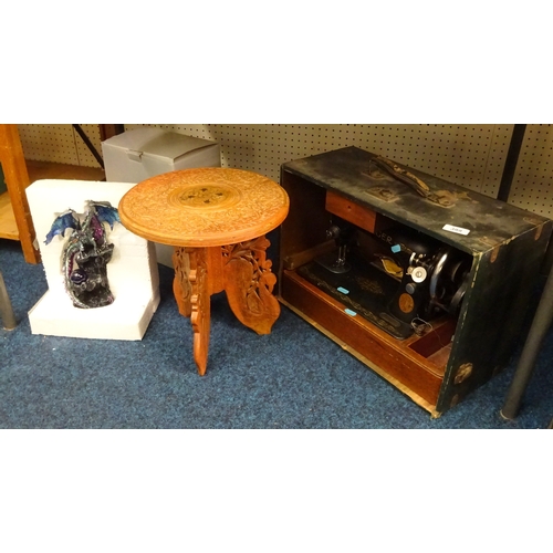 399 - A cased a Singer sewing machine together with a small carved table and a resin figure of a dragon.