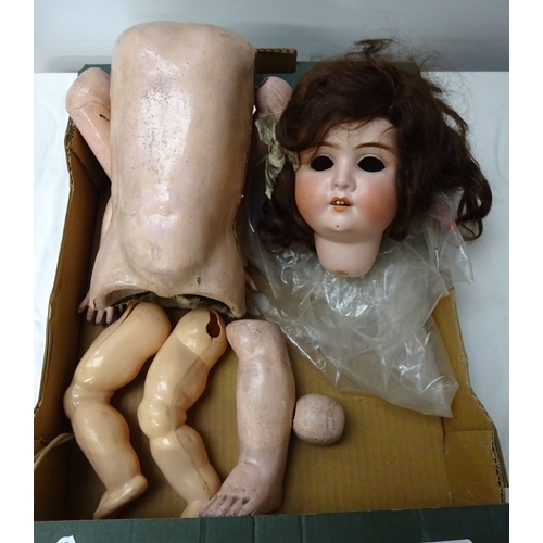 415 - A porcelain dolls head together with doll parts.