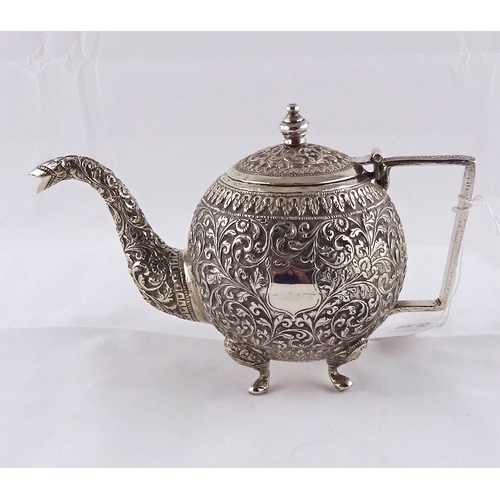 22 - A teapot having raised and chased decoration, Anglo-Thai / Siam white metal, approximately 200mm han... 