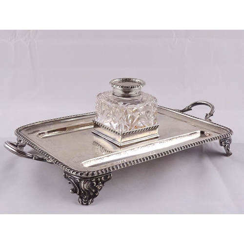 24 - A silver desk stand, with central glass and silver inkwell, London 1901.  294mm handle to handle / s... 