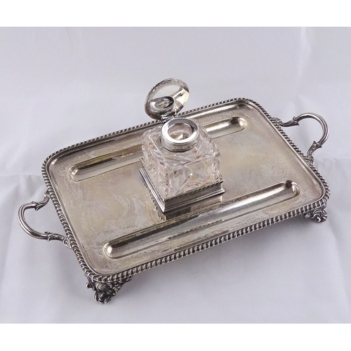 24 - A silver desk stand, with central glass and silver inkwell, London 1901.  294mm handle to handle / s... 