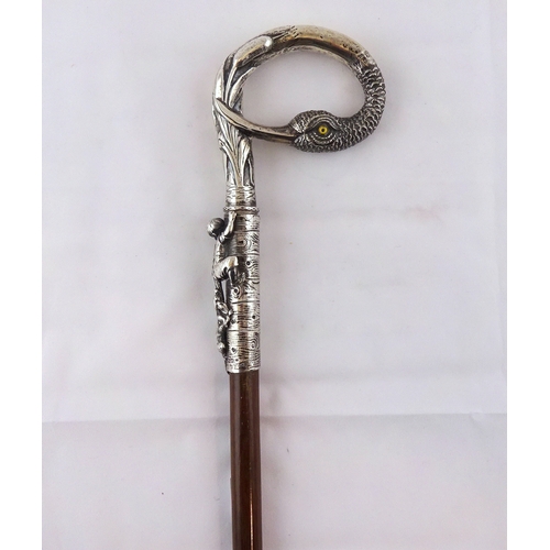75 - A walking cane having a cast continental white metal handle incorporating a duck's head and a child ... 