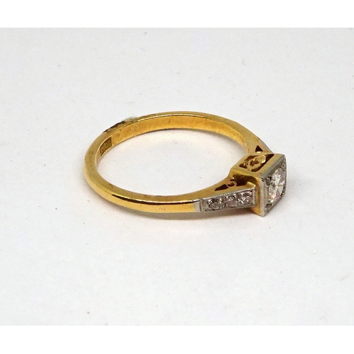 103 - A ring comprising a single brilliant cut white stone set in a square setting with stone set shoulder... 
