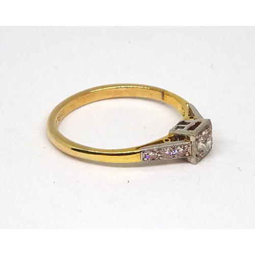 104 - A ring comprising a single brilliant cut white stone set in a square setting with stone set shoulder... 