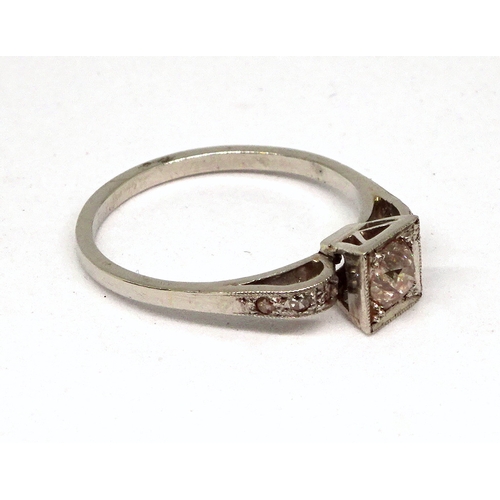 105 - A ring comprising a single brilliant cut white stone set in a square setting with raised, stone set ... 