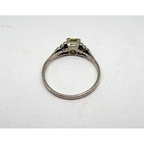 106 - A ring comprising a single brilliant cut stone with a pale yellow cast set in a square setting with ... 