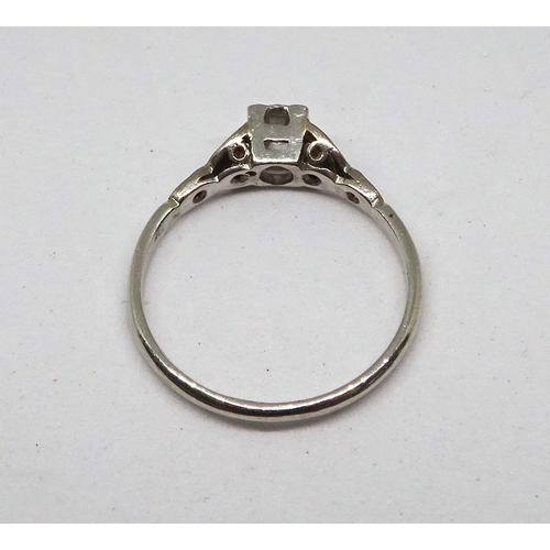 107 - A ring comprising a single brilliant cut white stone set in a square setting with stone set shoulder... 