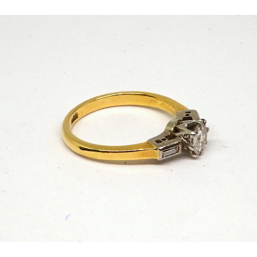 112 - A ring comprising a central brilliant cut white stone in a raised claw setting with baguette cut whi... 