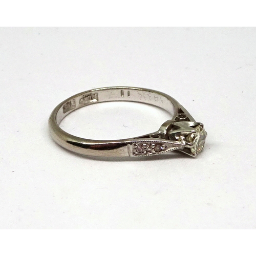 114 - A ring comprising a single brilliant cut white stone in a raised claw setting with stone set shoulde... 