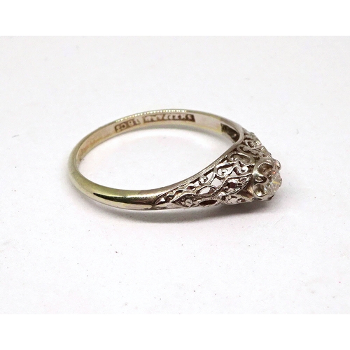 116 - A ring comprising an old cut white stone in a claw setting on openwork shoulders, white metal marked... 