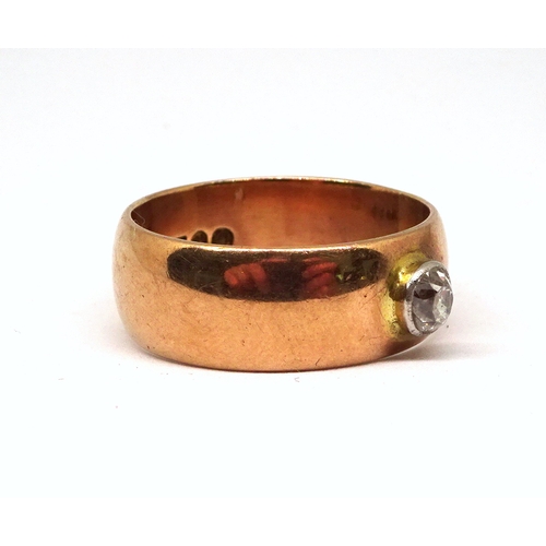 118 - A ring comprising an old cut white stone in a raised rub-over setting on a broad 9ct gold band.  8gr... 