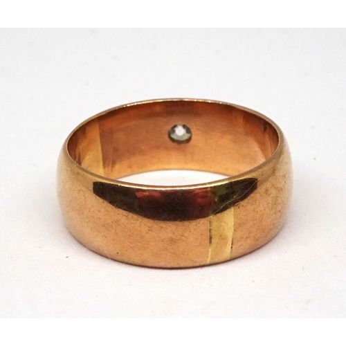 118 - A ring comprising an old cut white stone in a raised rub-over setting on a broad 9ct gold band.  8gr... 