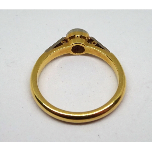 125 - A ring comprising a single brilliant cut white stone in a rub-over circular setting with stone set s... 