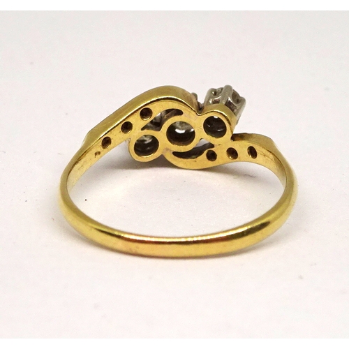 136 - A trilogy ring comprising three white stones in a raised claw setting with six further small white s... 