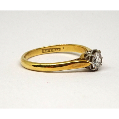 149 - A solitaire ring comprising a brilliant cut white stone in a white metal claw setting on a yellow me... 