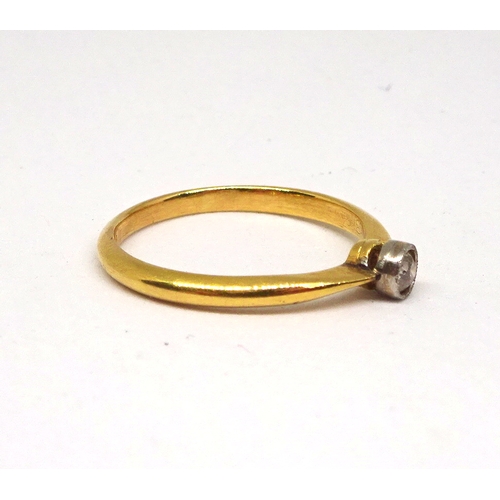 151 - A solitaire ring comprising an old cut white stone in a rub-over top setting, yellow metal marked 18... 