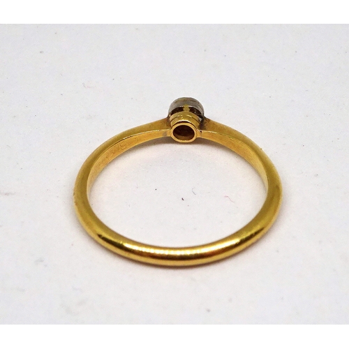 151 - A solitaire ring comprising an old cut white stone in a rub-over top setting, yellow metal marked 18... 