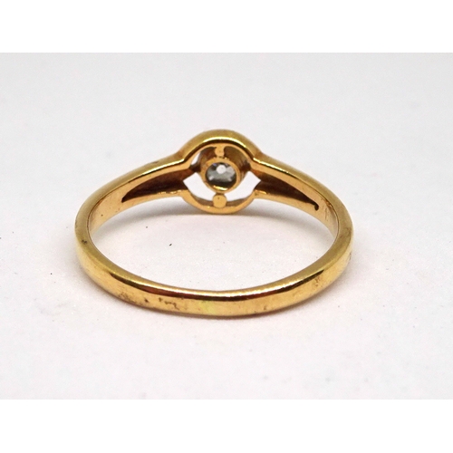 159 - A solitaire ring comprising a cushion shaped old cut white stone in a rub-over setting within a 