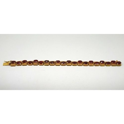 83 - A panel bracelet of textured design, yellow metal set with twenty amber coloured oval stones in an o... 