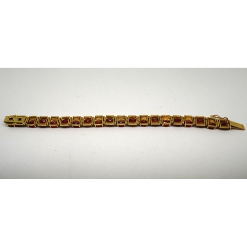 83 - A panel bracelet of textured design, yellow metal set with twenty amber coloured oval stones in an o... 