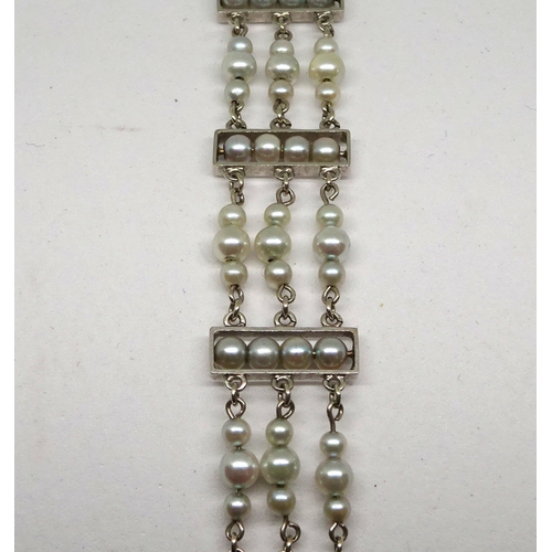 88 - A bracelet comprising 99 pearls on a white metal chain link setting marked 9ct.  182mm long / 13.5mm... 