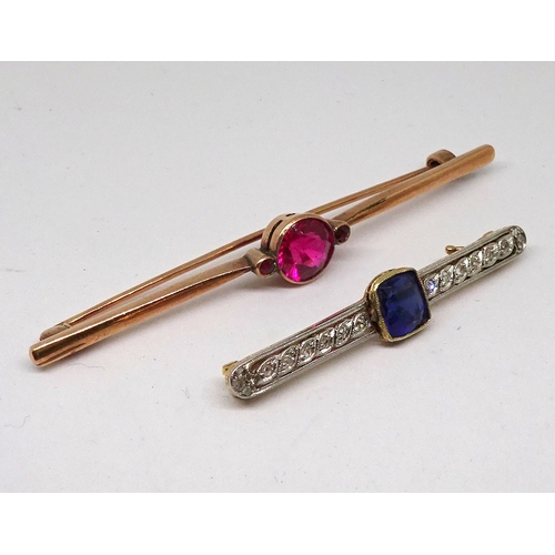 93 - A bar brooch marked 9ct and set with a central brilliant cut red stone, 68mm long / stone 7.5mm diam... 
