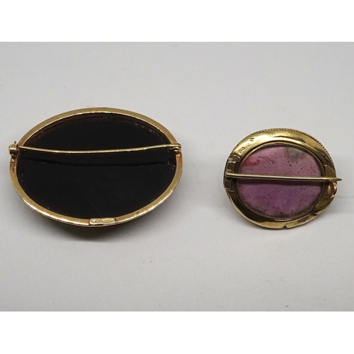 95 - A shell carved cameo on a black stone and yellow metal brooch mount, 42 x 32mm oval; a brooch having... 
