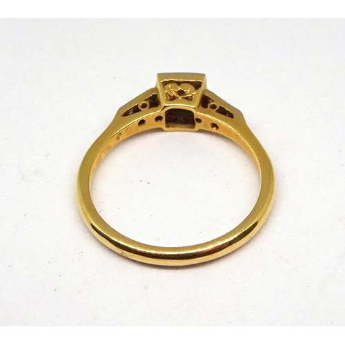 97 - A ring comprising a single brilliant cut white stone set in a square setting with raised, stone set ... 