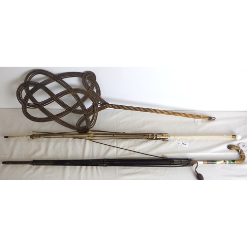 114 - A carpet beater; two parasol frames