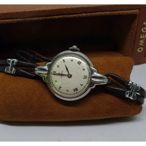 401 - An Omega ladies wristwatch in a steel case on a leather thong strap, presented in a period Omega bro... 