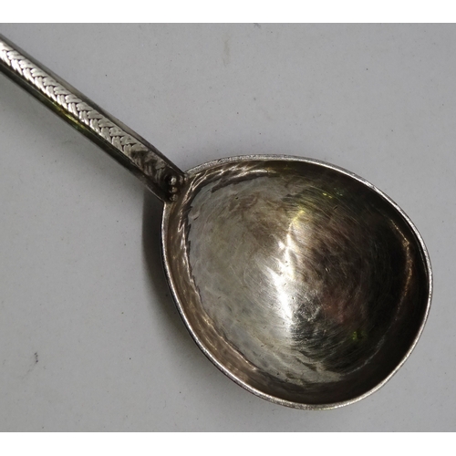 406 - An Arts and Crafts spoon having a planished pear shaped bowl, knotwork engraved stem and lotus motif... 