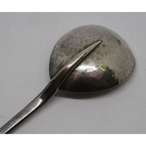 406 - An Arts and Crafts spoon having a planished pear shaped bowl, knotwork engraved stem and lotus motif... 