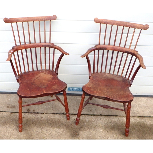 538 - A pair of oak comb back Windsor chairs, 92cm tall.