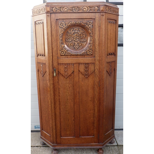 830 - A 1930's carved oak hall wardrobe, cracked central panel, 106cm wide, 45cm deep, 190cm tall