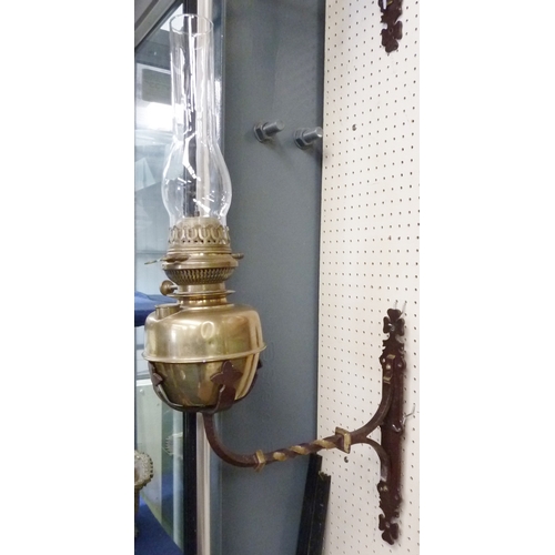 292 - A pair of brass oil lamps on wrought iron wall sconces