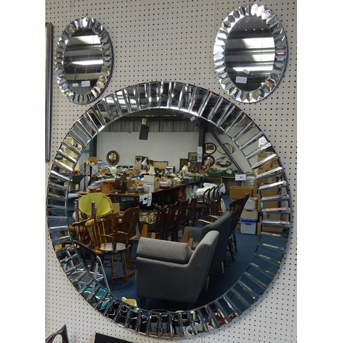 42 - A large modern circular mirror 100cm diameter, together with two small  oval mirrors. (3)