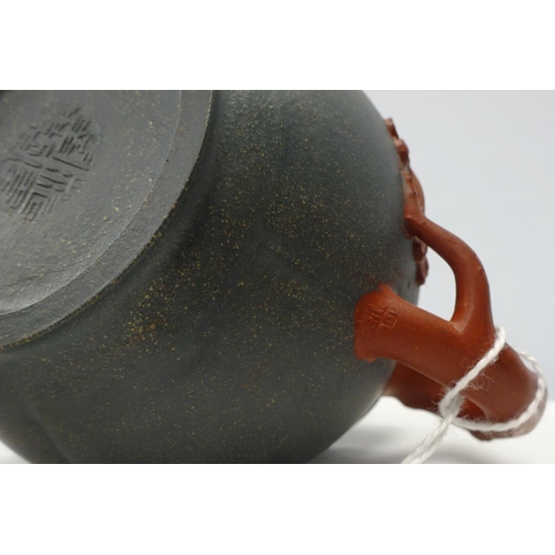 103 - A small green Chinese tea pot decorated with tree branches stamped to the base and the handle 10cm h... 