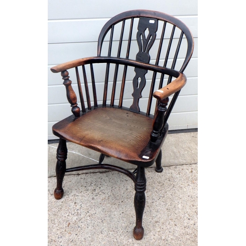 637 - A 19th cen dark stained, low backed Windsor chair with crinoline stretcher