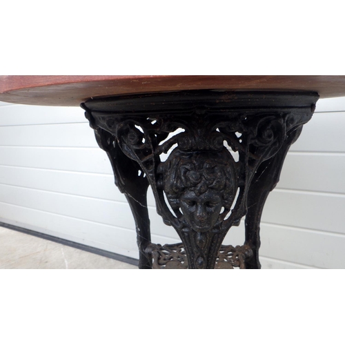 671 - A circular pub table with cast iron base, 68cm across