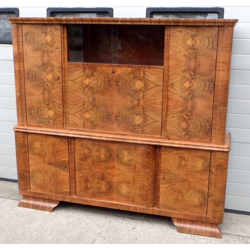 735 - A Continental 1930's burr walnut two section side cabinet with central drop down bar, in the manner ... 