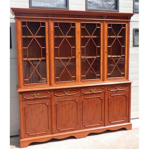 857 - A reproduction yew four door bookcase. (192cm wide)