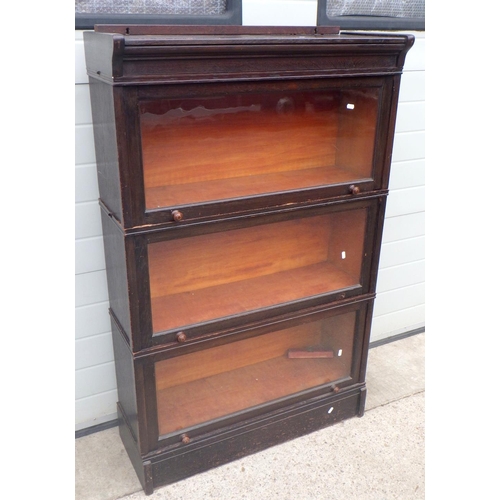 879 - A three section oak bookcase with up & over doors