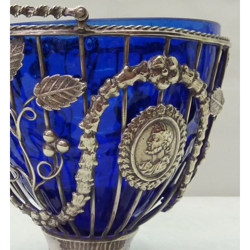 422 - A Victorian silver swing handled pedestal sugar basin, the wirework body decorated with swags, grape... 