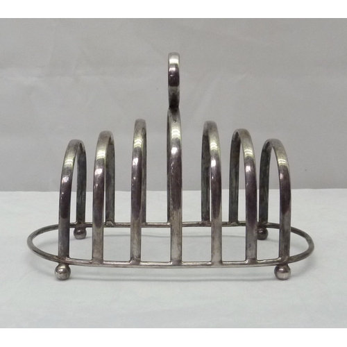 424 - A silver sauce boat standing on scallop mounted hoof feet; a silver toast rack, both early 20th cent... 