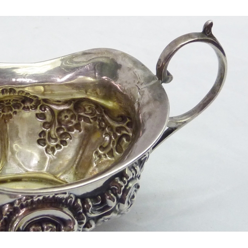 428 - A silver cream jug having repousse decoration, early 20th cent; a modern silver snuff box having dog... 