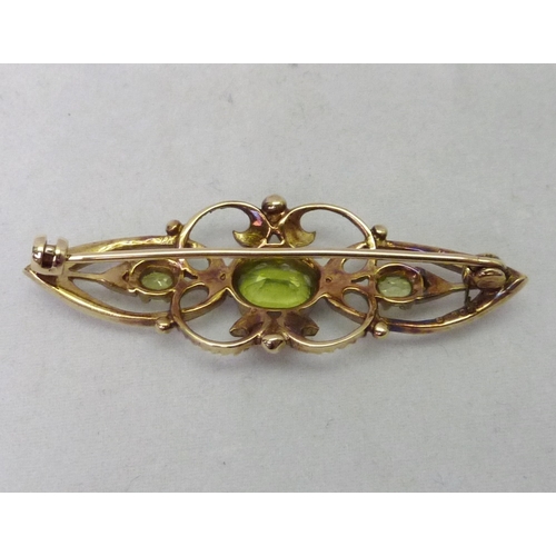 376 - A brooch comprising three green stones and sixteen seed pearls in an openwork 