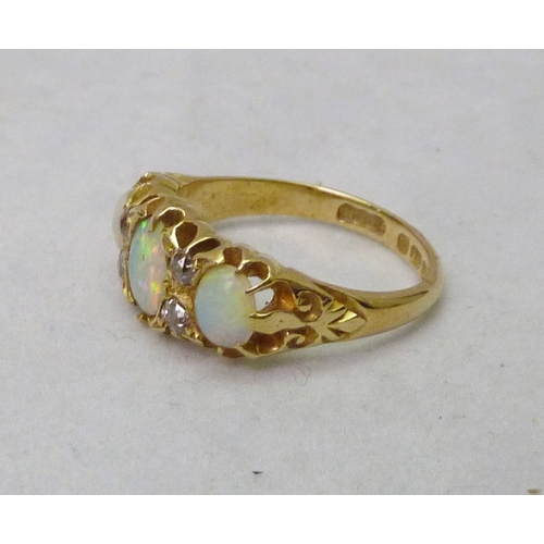 380 - An Edwardian ring set with three opals and four brilliant cut white stones, 18ct gold, Birmingham 19... 