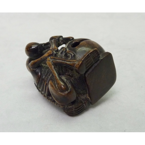 391 - A netsuke depicting a skeleton drummer, carved hardwood, signed to base