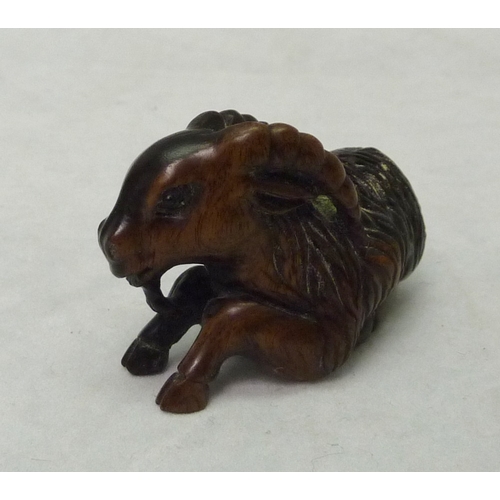 392 - A netsuke depicting a ram, signed to front leg, carved hardwood, 50mm long.