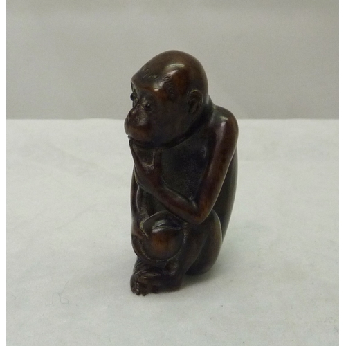 393 - An okimono depicting a seated monkey, carved hardwood, 50mm tall